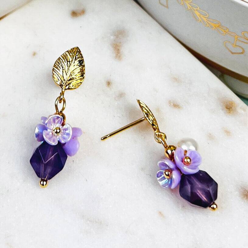 SchwesterSchwester Kleine vergoldete Ohrstecker in Blattform mit Blüten und Perle in Violett Begrenzt auf 3 Tage